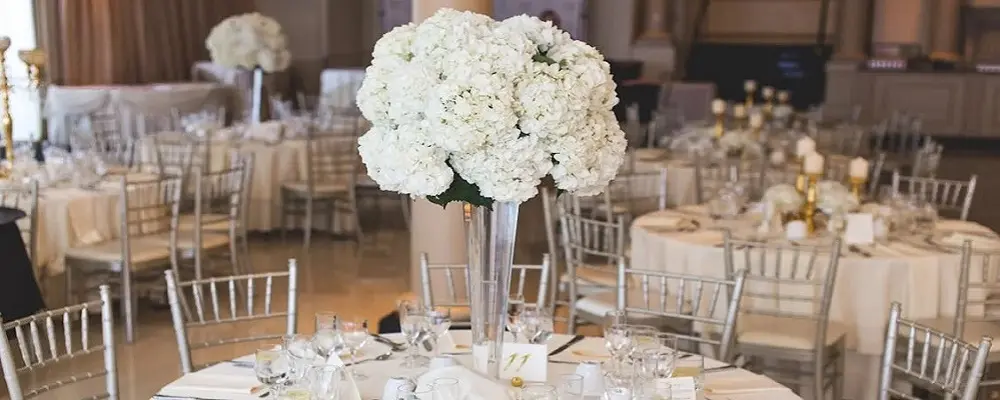 Centro de mesa con florero alto y flores blancas