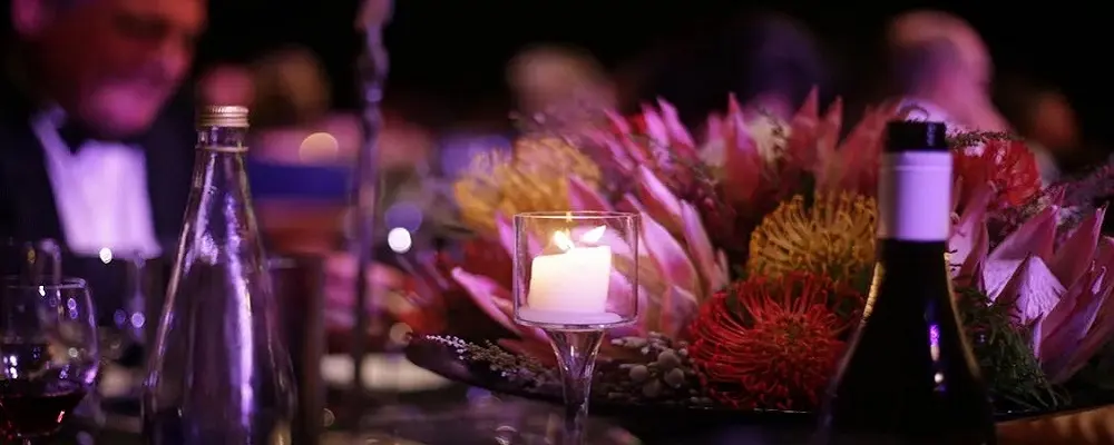 Centro de mesa con velas prendidas en fiesta de noche