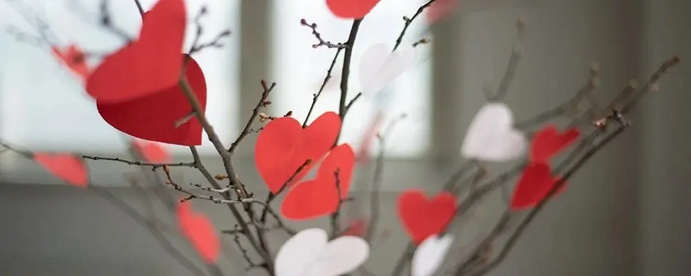 Centro de mesa con ramas y corazones rojos y blancos